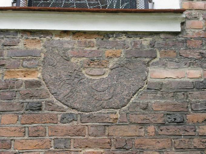 Fragment kamienia (prawdopodobnie  młyńskiego) wmurowany w ścianę wieży kościoła farnego.<BR>Widać  wykute w nim symbole.