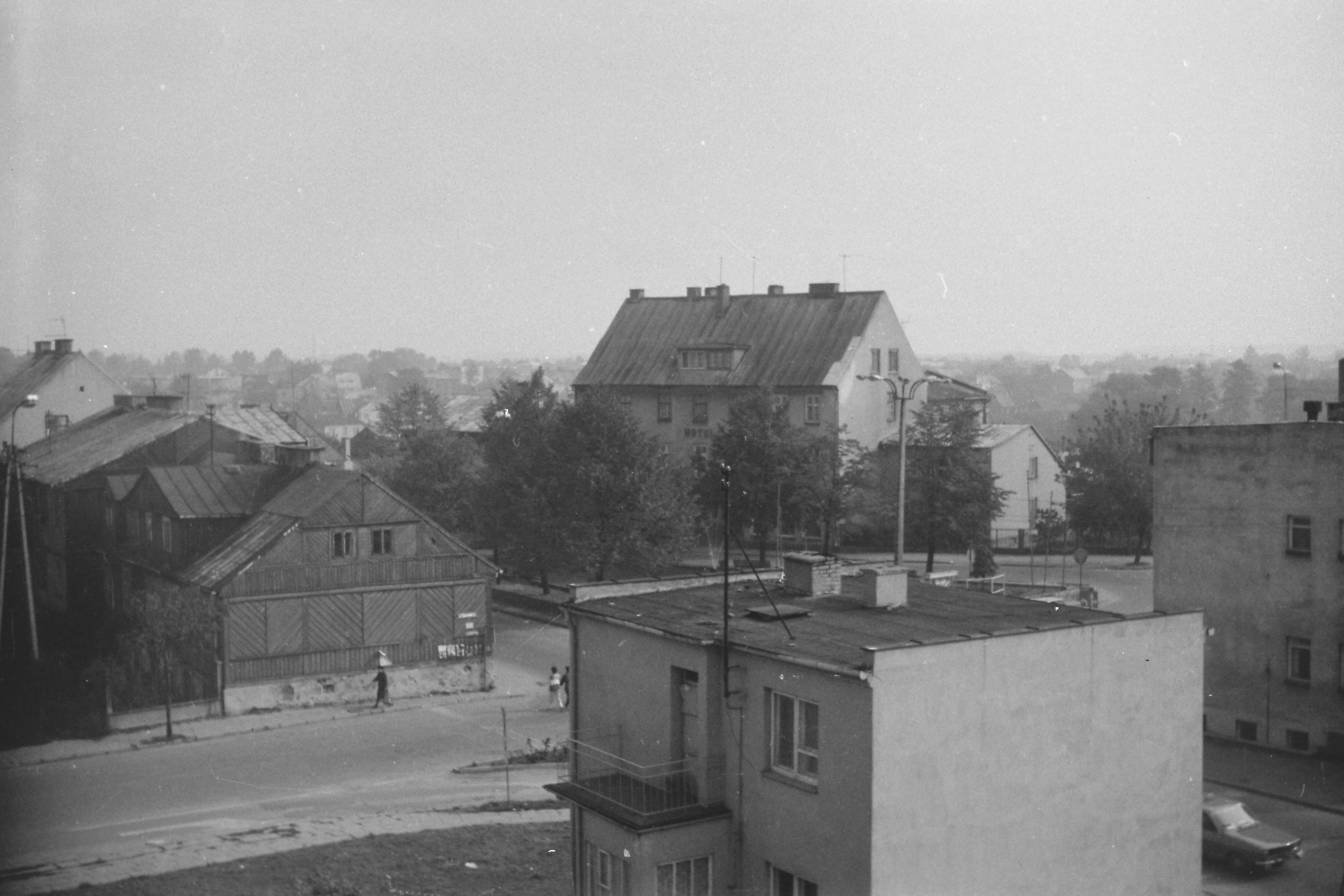 Zdjęcie wykonane w 1986 r., przedstawia widok na skrzyżowanie ulic Narutowicza i Piastowskiej z nieistniejącą obecnie drewnianą zabudową.