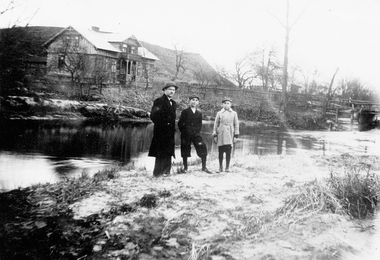 Prywatna fotografia z roku 1932. Przedstawia Stanisława Białoskórskiego z synami Henrykiem i Janem.<BR>W tle drewniany dom, stojący do dziś, dalej wzgórze, na którym obecnie znajduje się cmentarz.