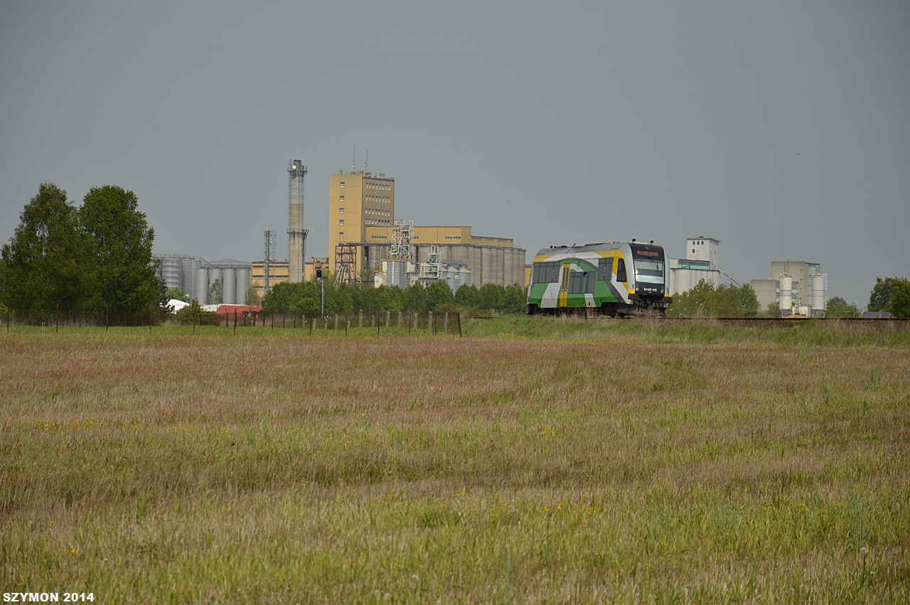 Autobus szynowy SA135-015 spółki Koleje Mazowieckie opuścił stację Sierpc i mija sierpecki browar, pociąg osobowy 51344 relacji Sierpc - Kutno, 7.05.2014 r.